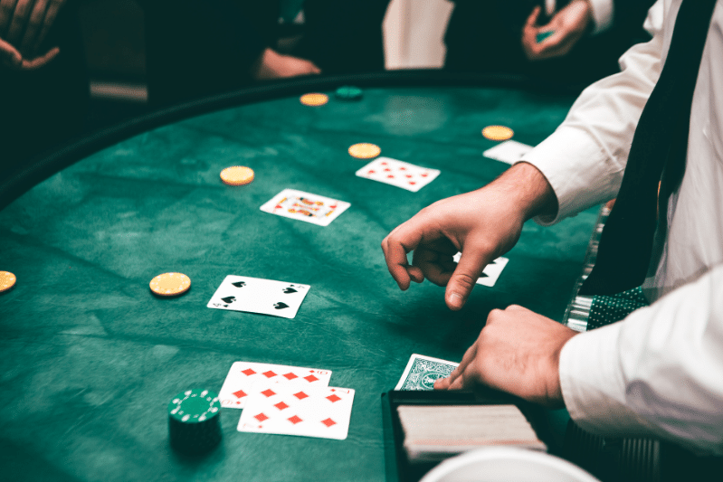 homem colocando cartas na mesa simbolizando a estratégia e a tomada de decisão nos jogos de azar